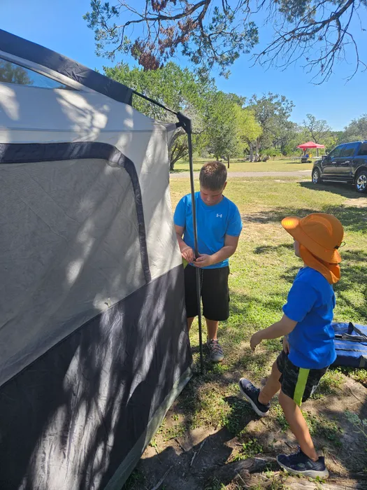 Scouts working together beside a tent