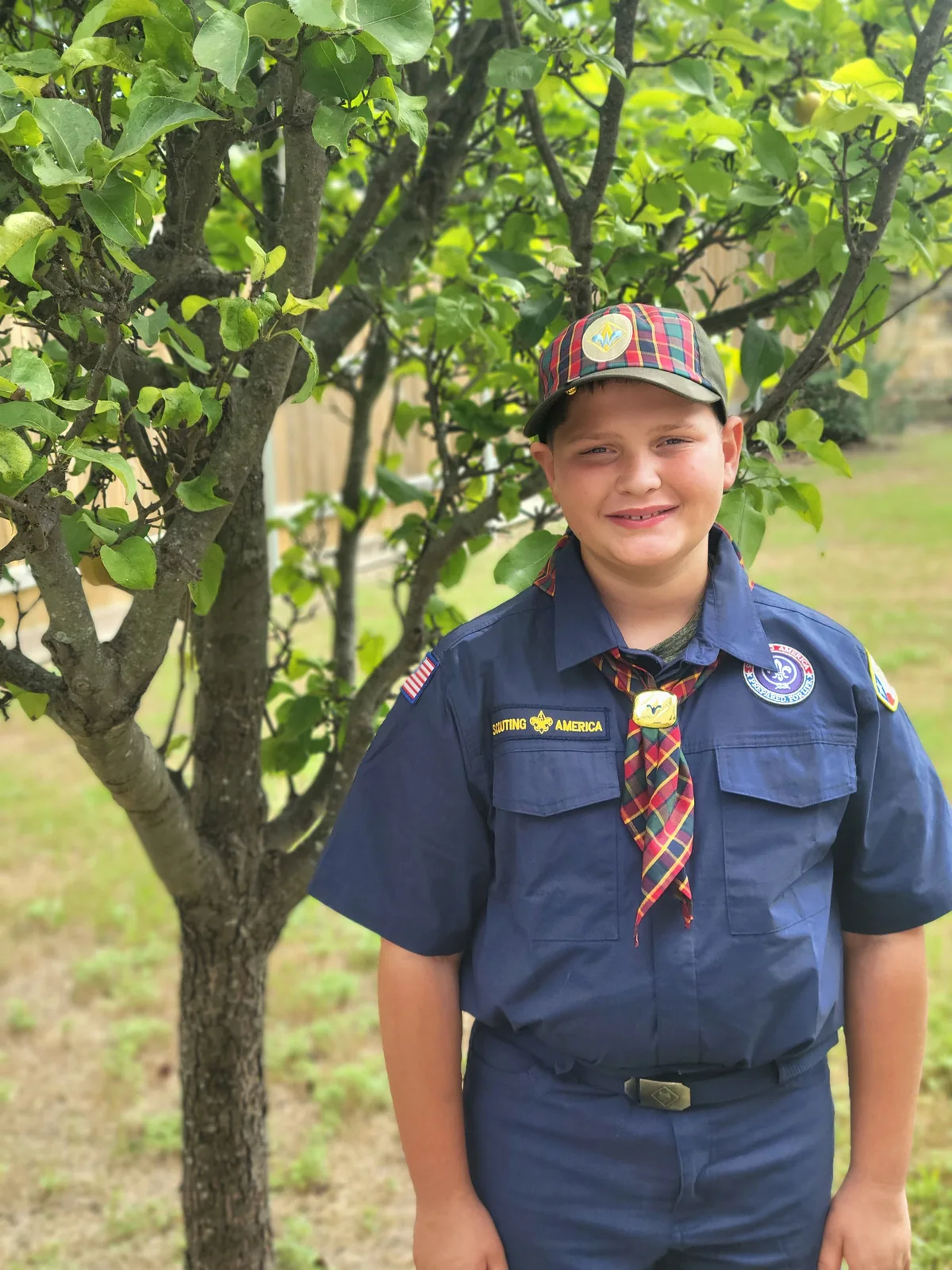 Wyatt smiling outdoors in his current Webelos Scout uniform